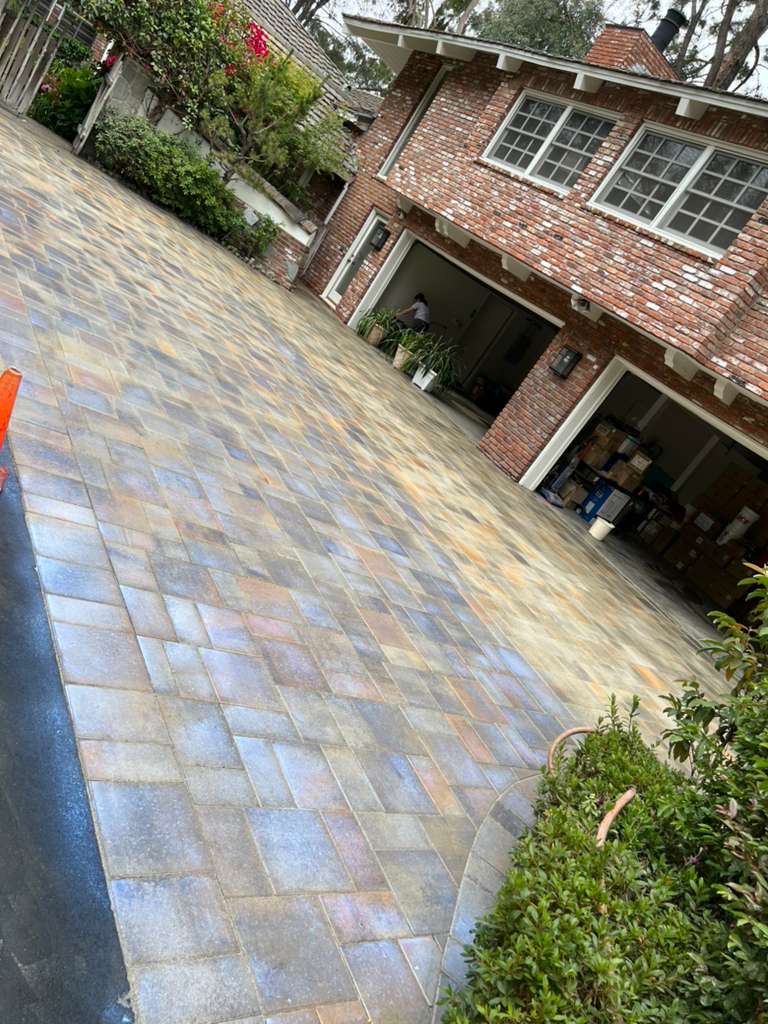 Elegant brick home with herringbone pattern paver driveway