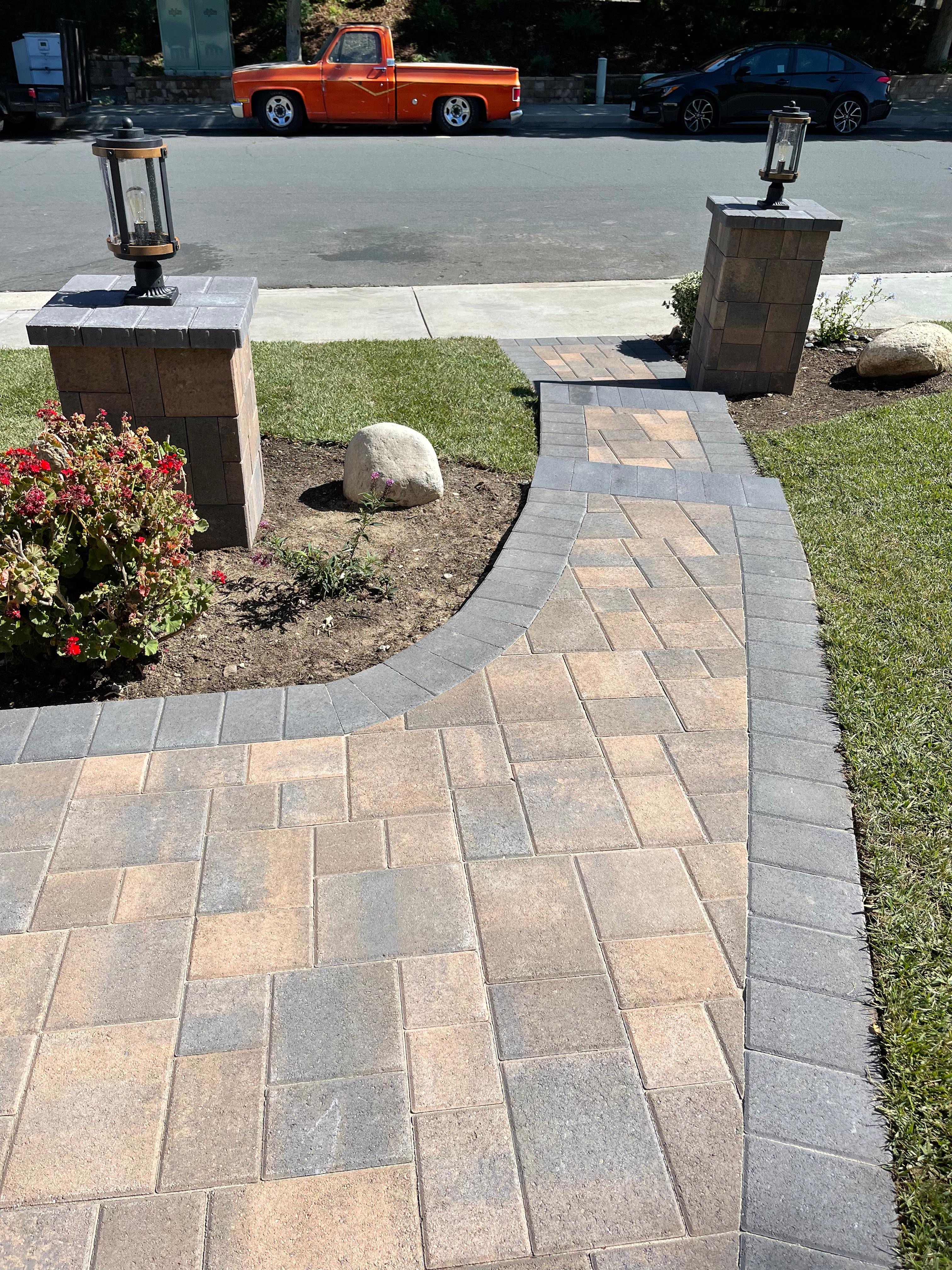 Curved paver walkway with decorative pillar lights