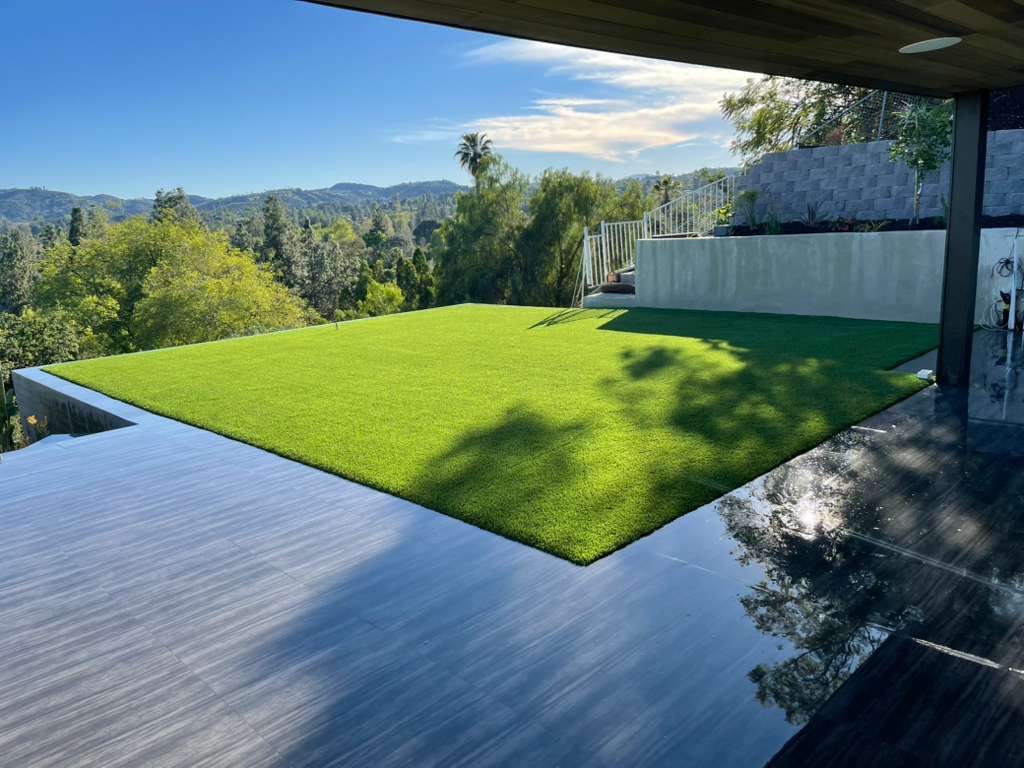Modern hillside turf installation with tile patio