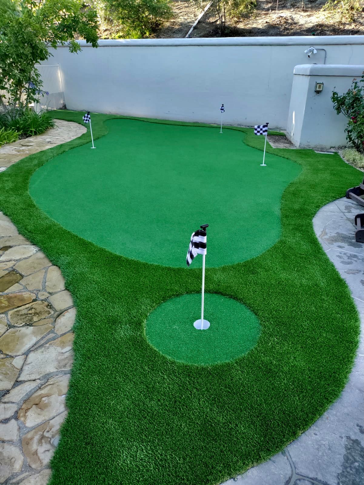 Custom backyard putting green with stone pathway