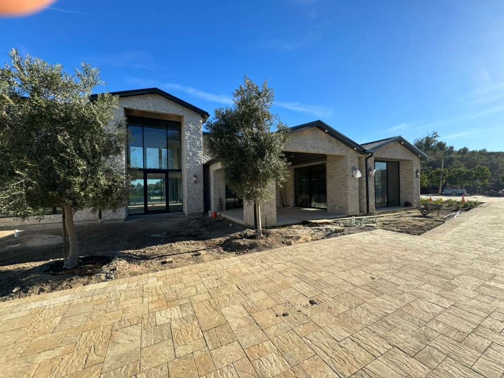 Large stamped concrete driveway at modern stone home